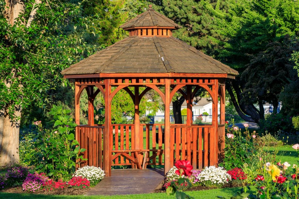 Ein Pavillon aus Holz steht im Garten 